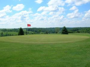 a golf course with a red flag in a green field at Deer Valley Lodge in Barneveld