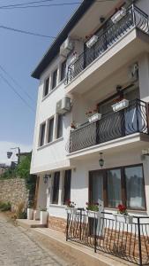 un grand bâtiment blanc avec des tables et des balcons dans l'établissement Villa Srma, à Ohrid