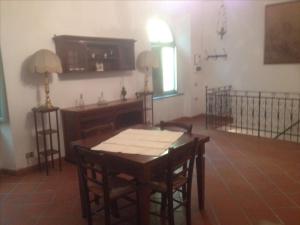 uma sala de jantar com uma mesa e cadeiras e uma televisão em Casa di Anchiano em Borgo a Mozzano