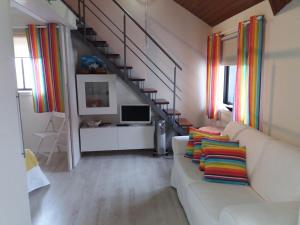 プライア・ダ・バーラにあるSossego Da Riaのリビングルーム(白いソファ、カラフルな枕付)