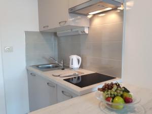 uma cozinha com um lavatório e uma taça de fruta em Apartments Nika em Trogir