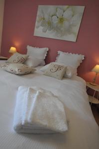ein Bett mit weißen Decken und Kissen darauf in der Unterkunft B&B Le Verger du Pierroy in Louftémont