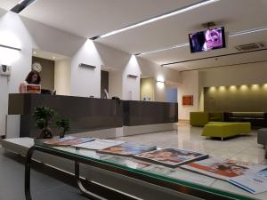 kobieta stojąca w holu ze szklanym blatem w obiekcie Hotel Artemide w mieście Aversa
