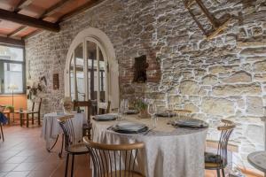 a dining room with a table and a stone wall at Agriturismo Petrarosa in Neviano degli Arduini