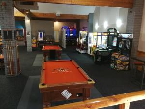 Habitación con mesa de billar y varios videojuegos en Ascot Oamaru Motel, en Oamaru