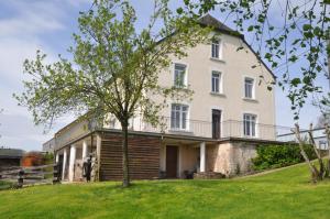 ein großes weißes Haus mit einem Baum im Hof in der Unterkunft B&B Le Verger du Pierroy in Louftémont