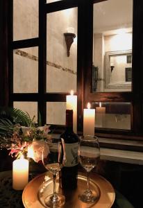 - une table avec deux verres de vin et des bougies dans l'établissement Casa Degraciela - Hotel Boutique, à Concepción de Ataco