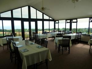 a dining room with tables and chairs and windows at Monturpie Guest House in Kirkton of Largo