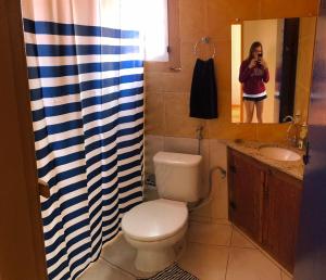 Eine Frau, die ein Bild von einem Badezimmer mit Toilette macht. in der Unterkunft Casa de hospedagem Mimos de Minas 2 in Tiradentes + 16 Fotos