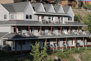 a large white house with chairs on the porch at Absaroka Lodge in Gardiner