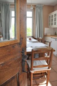 a wooden door in a kitchen with a table at B&B Le Verger du Pierroy in Louftémont