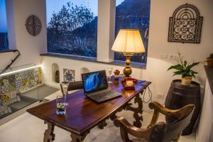laptopa siedzącego na drewnianym stole w pokoju w obiekcie Villa Pietra Santa w mieście Positano