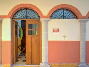 una casa con dos arcos y una puerta de madera en Hotel Luz en Yucatan en Mérida