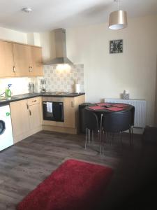 a kitchen with a black table and a red rug at River Ness Apartments in Inverness