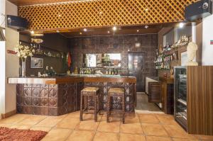 un bar en un restaurante con taburetes en una habitación en Rosamar Apartamentos, en Armação de Pêra 21 fotos más