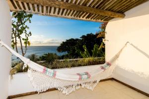 a hammock in a room with a view of the ocean at Pousada Natureza in Morro de São Paulo