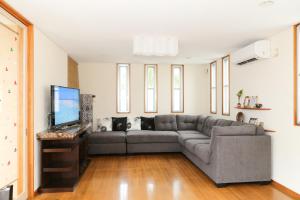 a living room with a couch and a flat screen tv at Palm Villa Ishigakijima igusa in Ishigaki Island