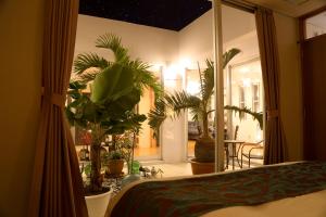 a bedroom with potted plants and a room with a bed at Palm Villa Ishigakijima igusa in Ishigaki Island
