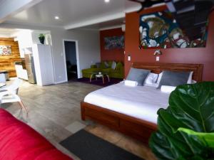 a bedroom with a large bed and a living room at ArtHOUSE Beachfront Accommodation in Emerald Beach