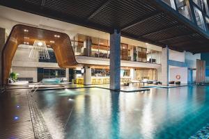 uma piscina num grande edifício com piscina em The Margo Hotel em Depok