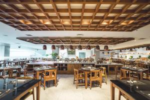 a restaurant with wooden tables and chairs and a bar at The Margo Hotel in Depok