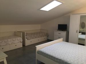 a bedroom with two beds and a television in it at Playa Bella in Pérols