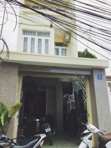 une maison avec des motos garées à l'extérieur d'un garage dans l'établissement Chang Homestay, à Nha Trang