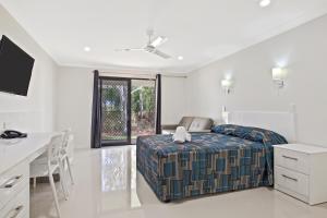 a bedroom with a bed and a table and a desk at Casa Nostra Motel in Rockhampton