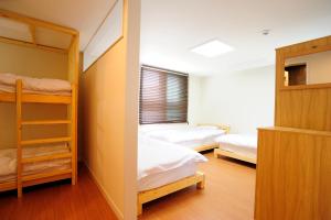 a bedroom with two bunk beds and a window at Hannah Guesthouse in Jeju