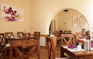 uma sala de jantar com mesas e cadeiras de madeira em Gut Hotel Stadt Beelitz em Beelitz