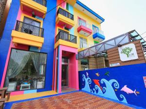 墾丁的住宿－优閒民宿，一座色彩缤纷的建筑,旁边有一幅画