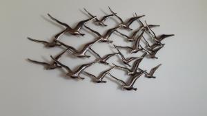 a group of birds metal wall sculpture at Aux Premières Loges in Fécamp