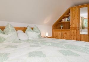 una camera da letto con un grande letto bianco con cuscini di Promschhof a Semriach