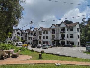 un grand complexe d'appartements avec des voitures garées dans un parking dans l'établissement H2O Apartment, à Cameron Highlands