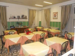 Albergo Belvedere في بورغيتو دي فارا: غرفة طعام مع طاولات وكراسي وستائر