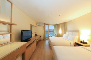 Una televisión o centro de entretenimiento en Ocean Suites Jeju Hotel