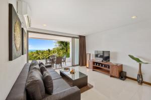 a living room with a couch and a television at Tranquil Residence 2 - Luxury Apartment in Lamai