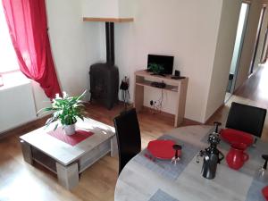 a living room with a table and a stove at la grange de loghju in Villefort