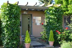 eine Haustür eines Hauses mit Pflanzen und Blumen in der Unterkunft Quartier SansSouci Hostel in Potsdam