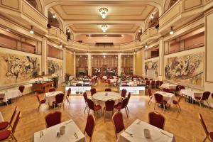 restauracja ze stołami, krzesłami i obrazami na ścianach w obiekcie Hotel Ariston Prague w Pradze