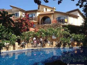 a house with a swimming pool in front of a house at Roman Boutique Hotel in Paphos