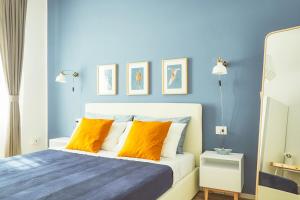 ラ・スペツィアにあるCasa Anne Marieの青いベッドルーム(オレンジ色の枕が付くベッド付)