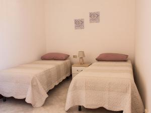 2 Betten nebeneinander in einem Zimmer in der Unterkunft Casa Vacanza Valledoria in Valledoria