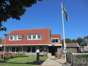 une maison arborant un drapeau devant elle dans l'établissement Paal 5, à Hollum
