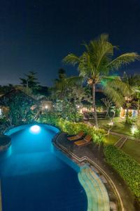 a view of a swimming pool at night at Outpost Ubud in Ubud