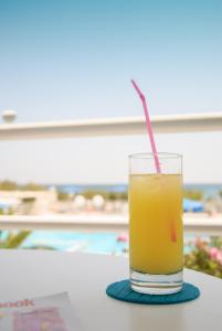 a glass of orange juice sitting on a table at Kouros Seasight Hotel in Pythagoreio