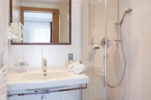 a bathroom with a sink and a shower at Appartement Hotel Garni Matthäuserhof in Gerlos