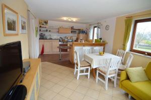 a kitchen and living room with a table and chairs at Ferienwohnung-BergIdylle-bei-Hotel-BERGHOF in Lichtenhain