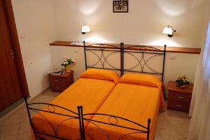 - une chambre avec un lit orange et deux oreillers orange dans l'établissement Locanda Dino, à Scandicci