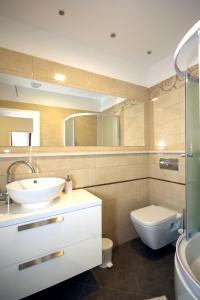 a bathroom with a sink and a toilet and a mirror at Villa Principessa Podstrana in Podstrana